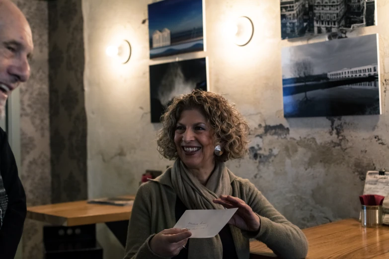 a woman smiling and holding a piece of paper