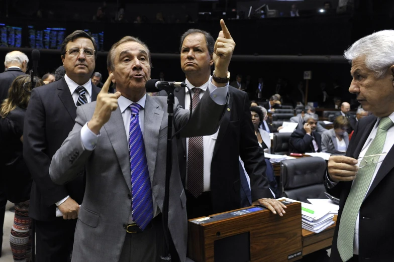 men are talking to each other while standing in front of the microphone