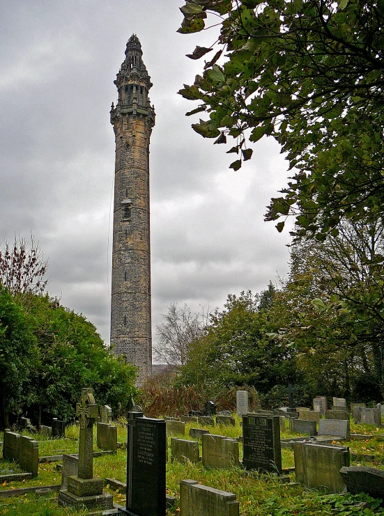 a po of an old cemetery with a tall pillar and headstones