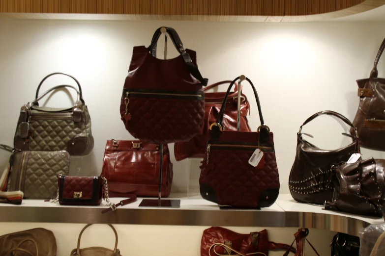 several leather purses lined up against a wall