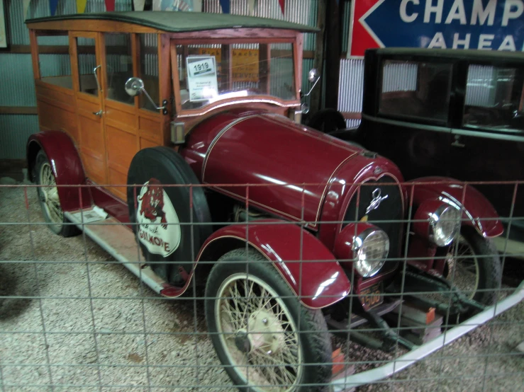 antique cars are displayed behind the metal gate