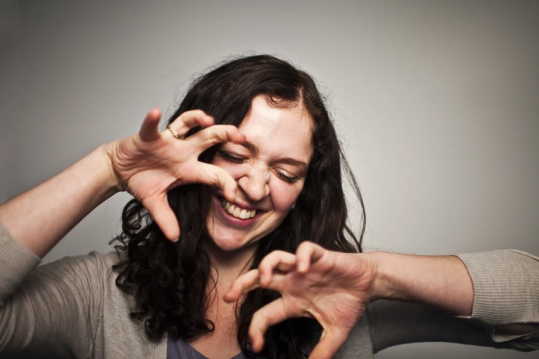 a woman making a heart with her hands