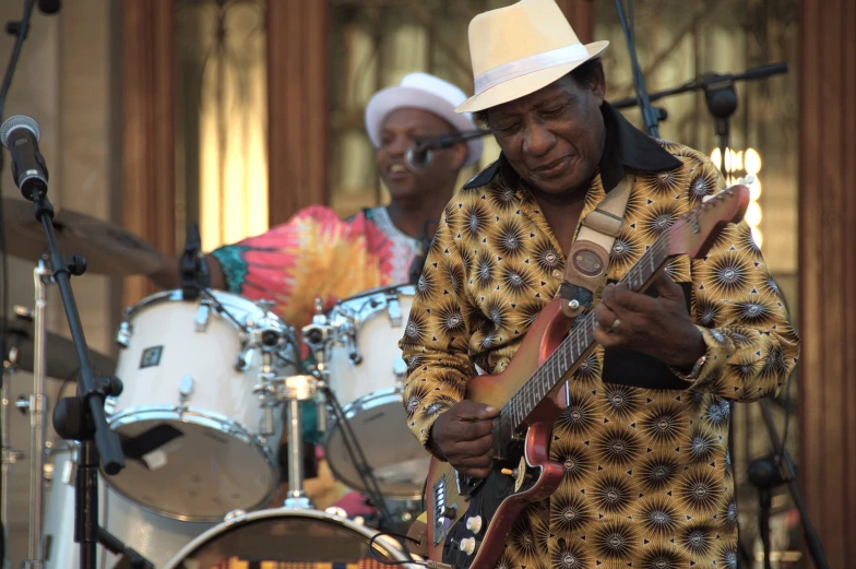 the music man is playing his guitar with others around him