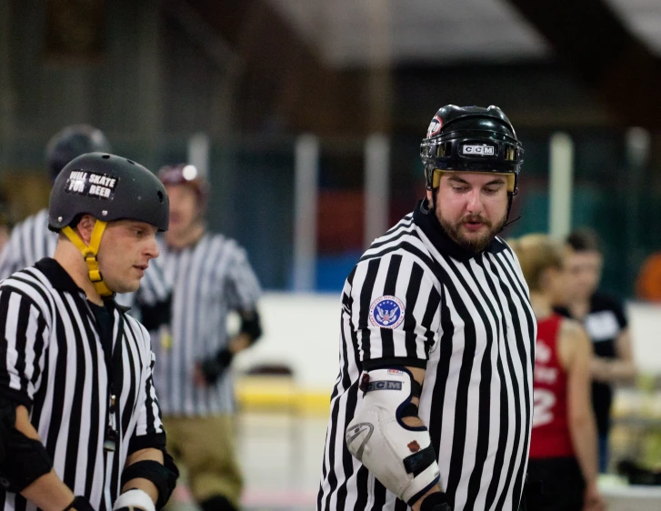 referee and referee standing in front of an ice rink
