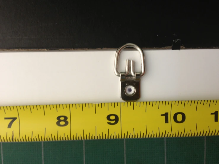 a measuring tape with a metal buckle in front of it