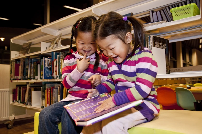 the two children are on the floor reading books