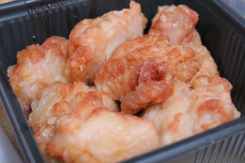 a close up of many chicken pieces in a tray