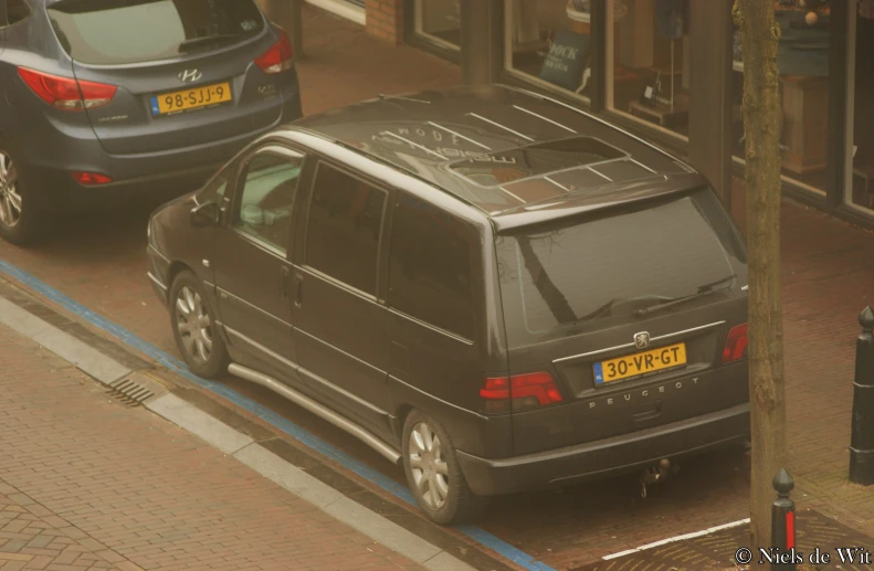 a dark vehicle is stopped at the curb