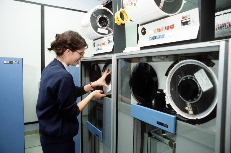 woman in dark clothes removing electronics from a machine