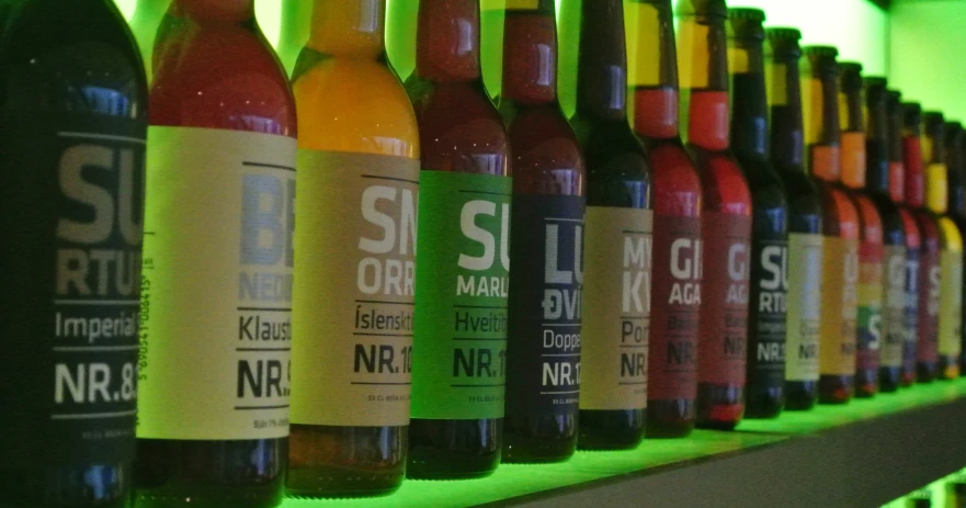 a shelf holding various beverages and condiments on a dark green wall