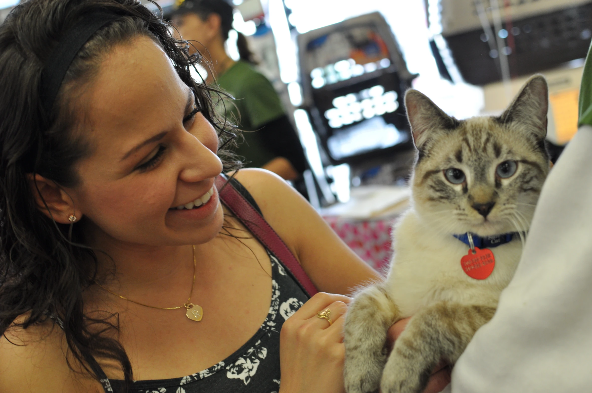 there is a woman holding a kitten in her arms