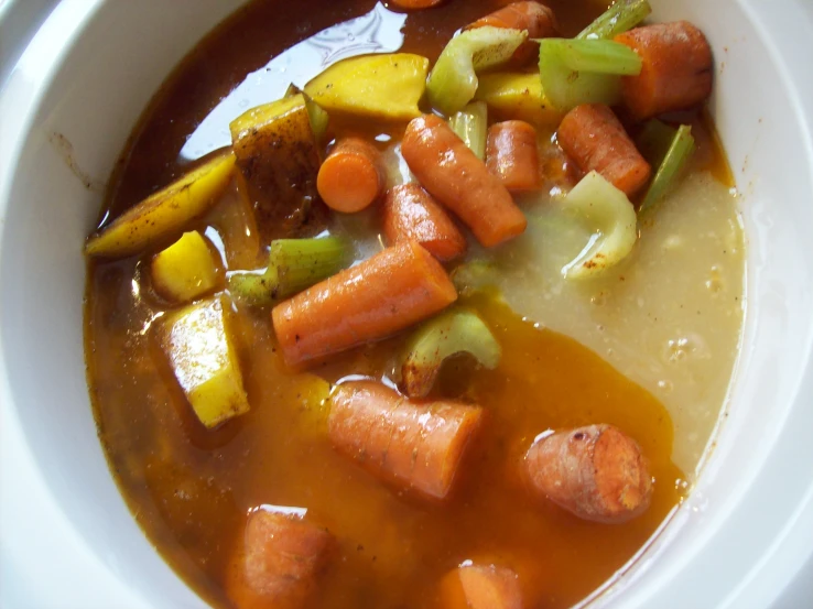 a bowl of soup with carrots, celery and broccoli