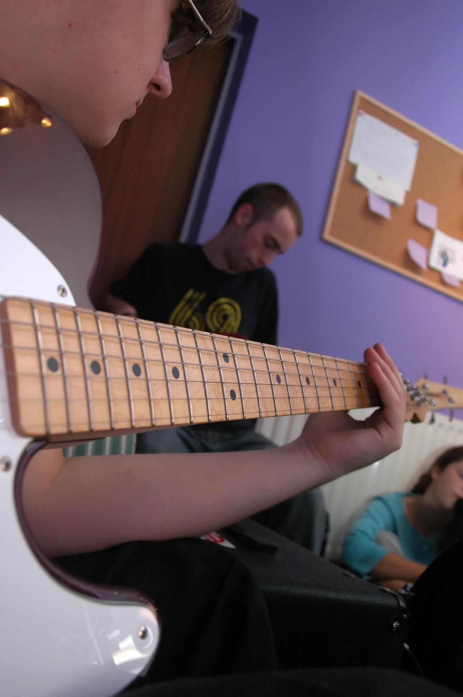 a young person playing on an electric guitar