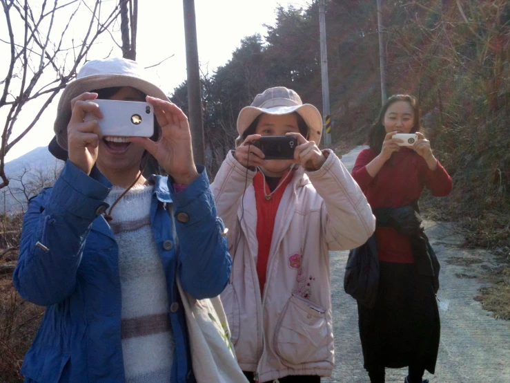 two people are taking pictures on a road