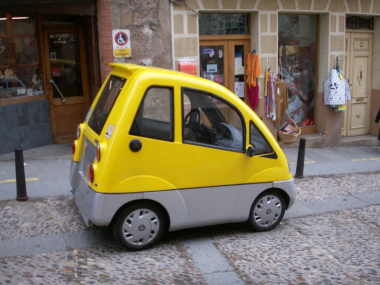 a small car is sitting in front of a store