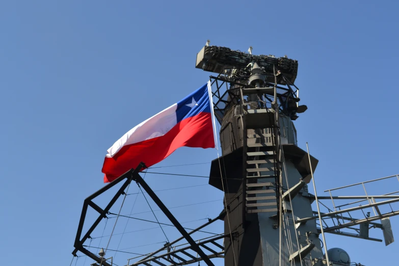 a large texas flag flying next to a tower