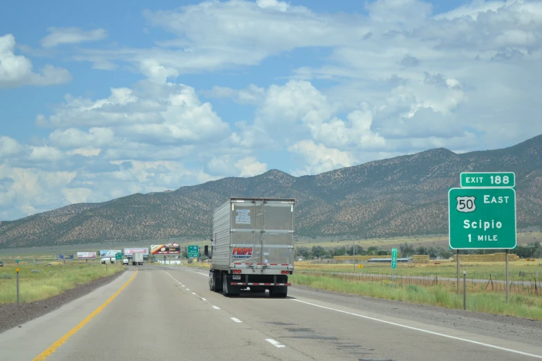 trucks and trailers travel along the freeway with their backs turned to look like they're leaving a border