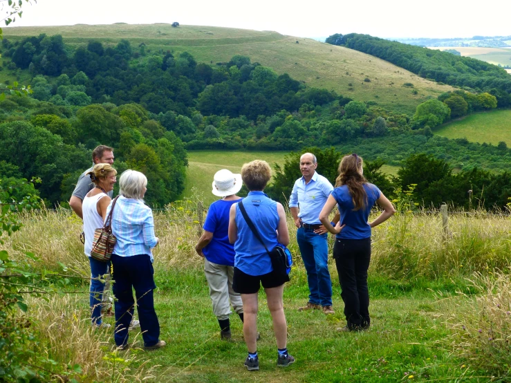 several people in blue shirts on a grass field