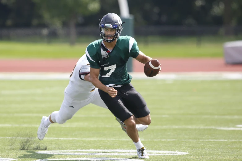 a football player holding a football on top of a field