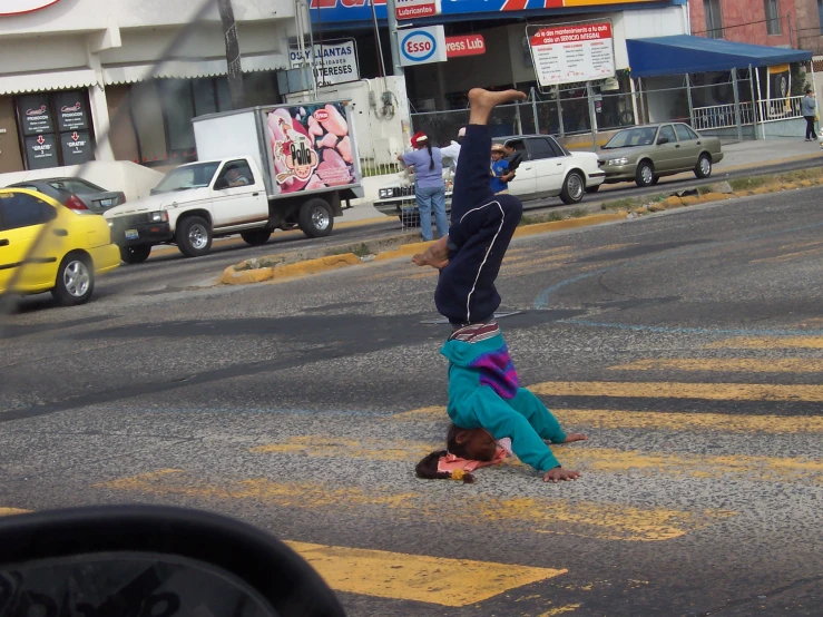 child upside down in a street next to a large yellow car