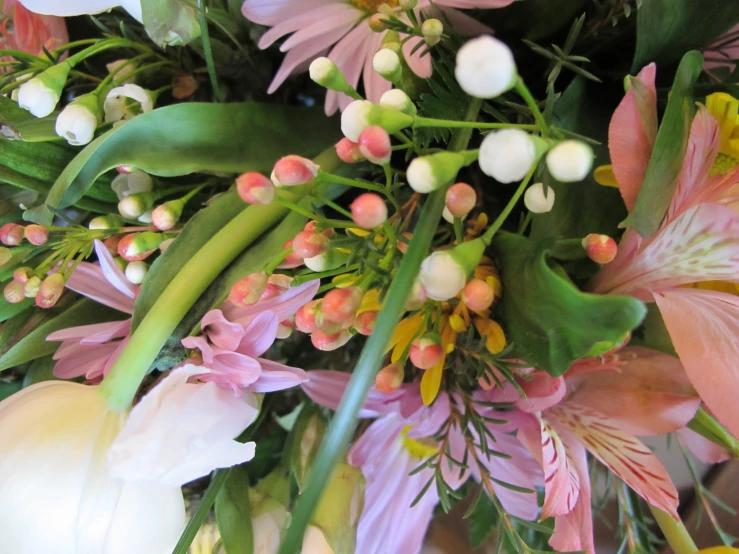 a bouquet of fresh flowers and greenery in a bouquet