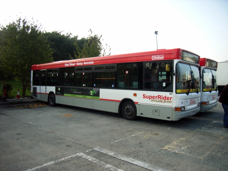 a man stands at the bus terminal, waiting to board