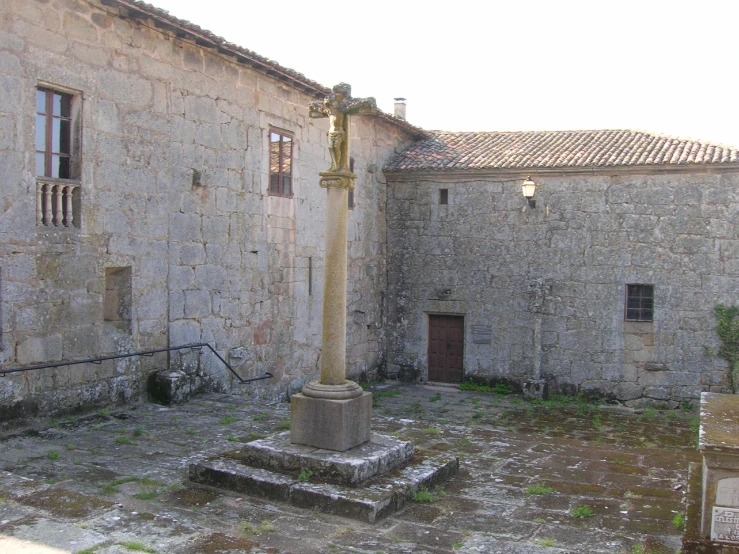 an abandoned stone building with a small cross on it