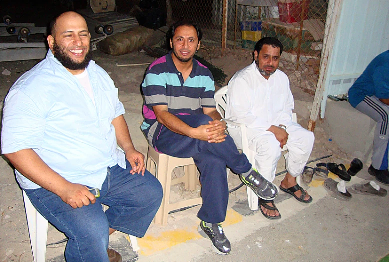 three people sitting down in an alley way