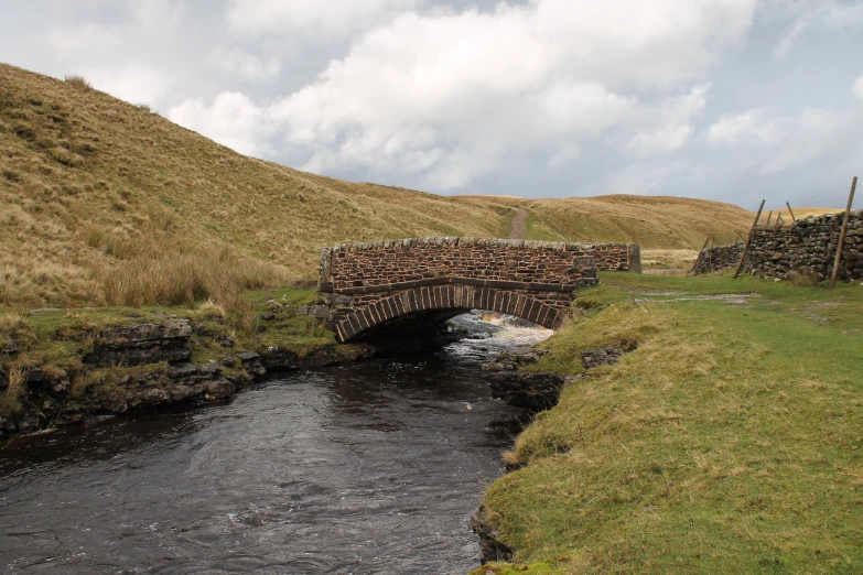 an outdoor stream running under an overpass in the field