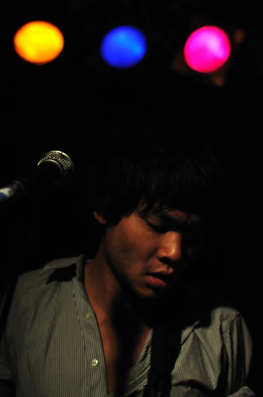 a young man standing next to a microphone