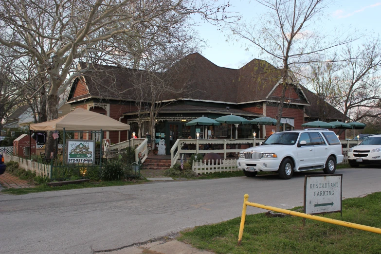 a restaurant in the street with vehicles parked outside it