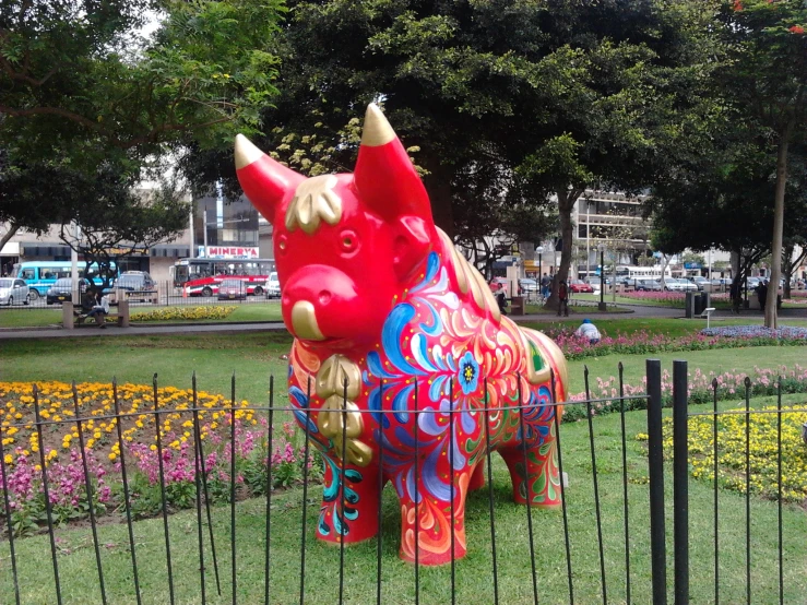 a statue of a colorful unicorn stands on grass