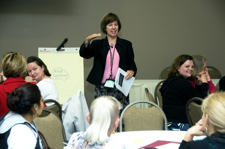 women in formal clothing are attending a meeting