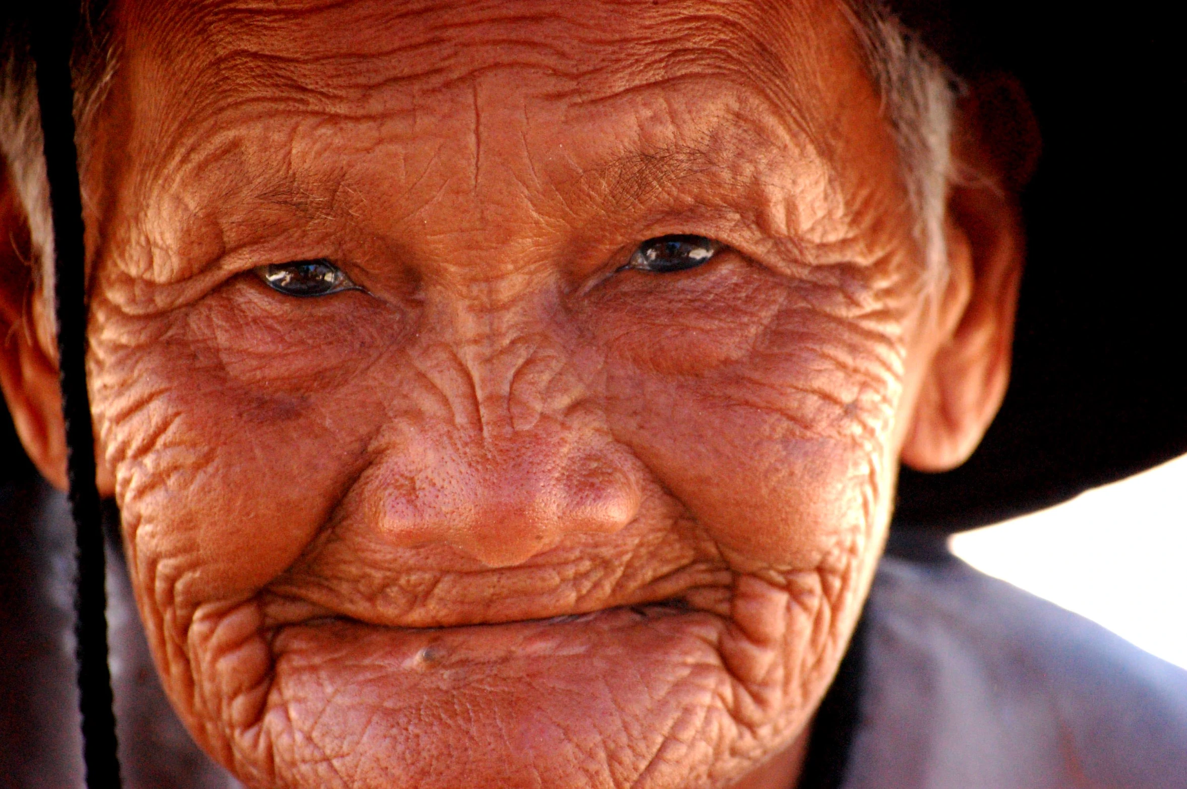 an elderly asian woman with wrinkles and black hats