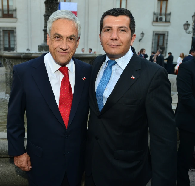 two gentlemen are posing for the camera at a social event