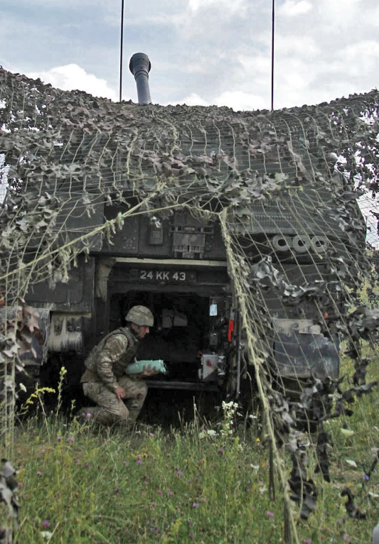 a man working on the back of a military truck