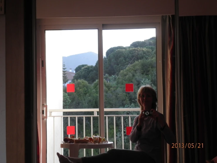 the woman is posing in her room for a picture with the view