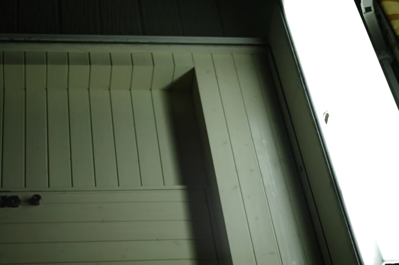 the open door to a closed garage on the side of a building