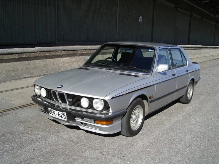 an old bmw parked on the street with its license plate