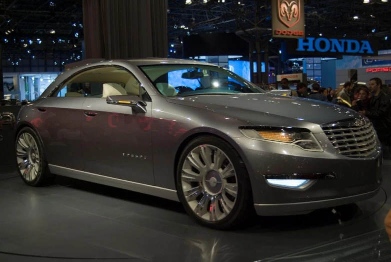 a gray car parked in front of a crowd