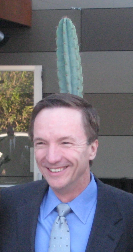 a man in a suit with a cactus on his head