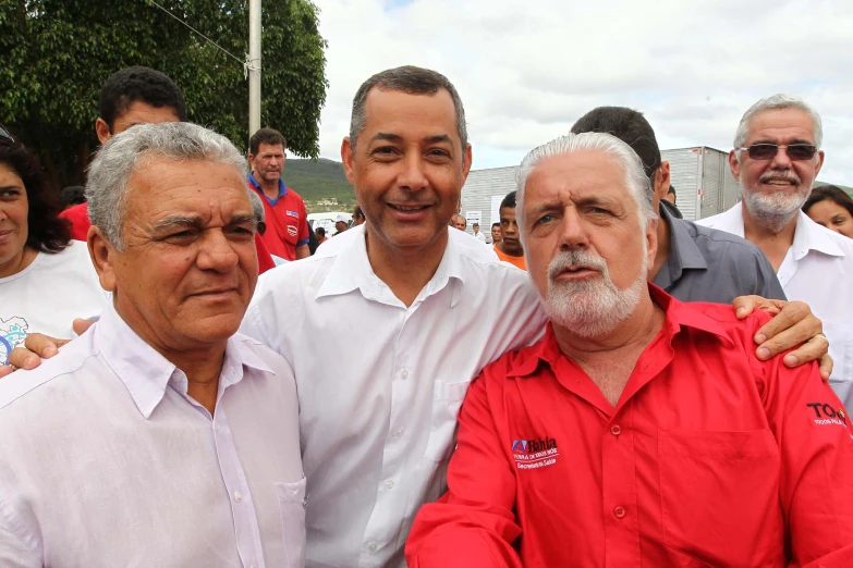 two men standing next to another man and another man