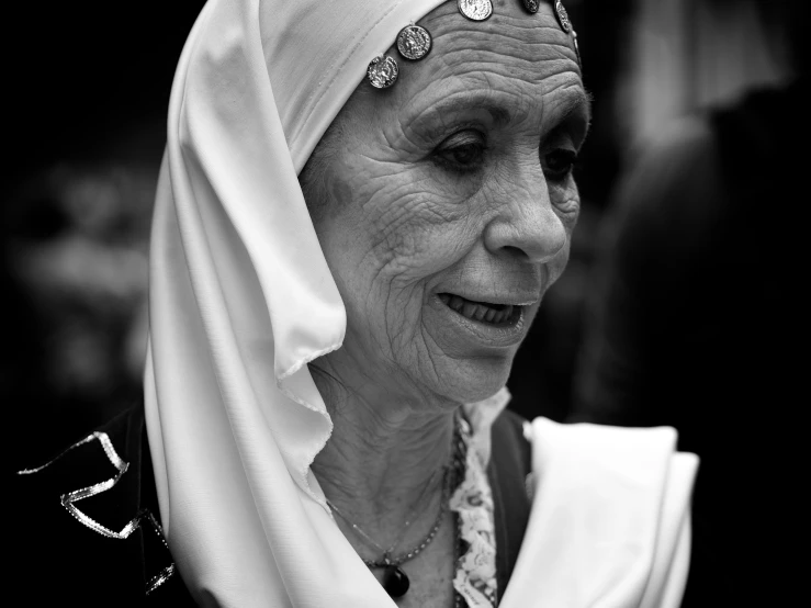 a woman in a white head scarf with jewelry and necklace