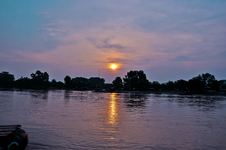 a boat in a body of water at sunset