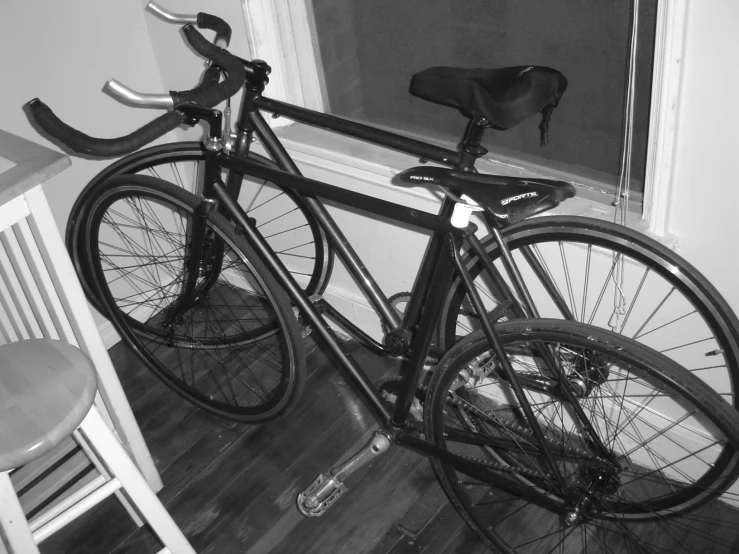 the black bicycle is propped up against the wall