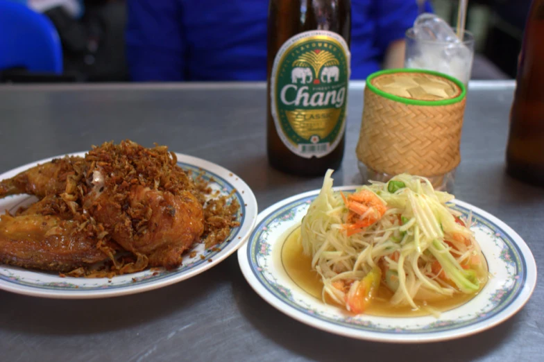 the two plates of food have noodles and beer on them