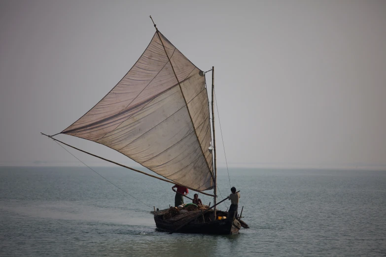 a boat with white sails on a lake