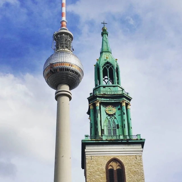 a steeple with a large tower behind it