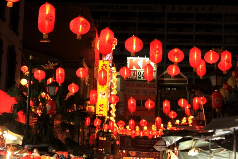 a city street has many red lanterns hanging above it