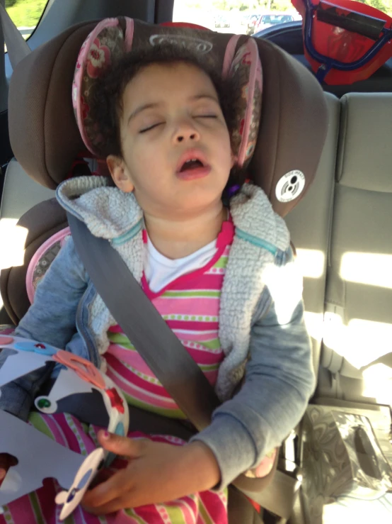  sleeping in car seat with head resting on harness